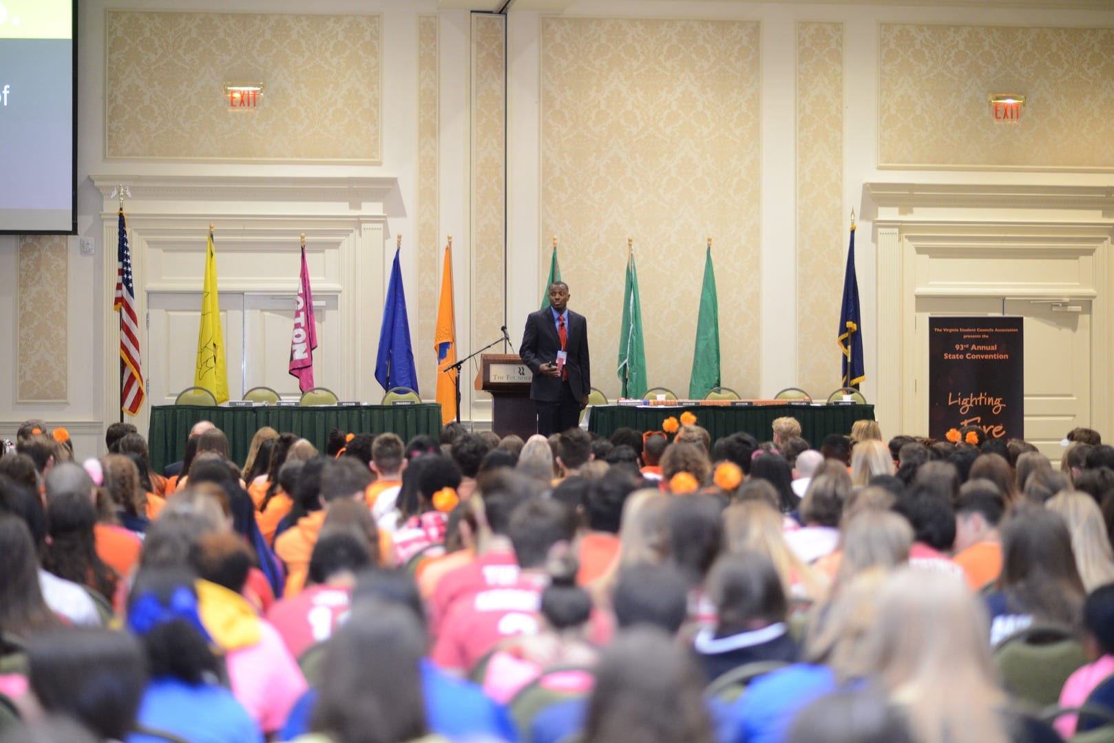 A large crowd of people sitting in front of a podium.